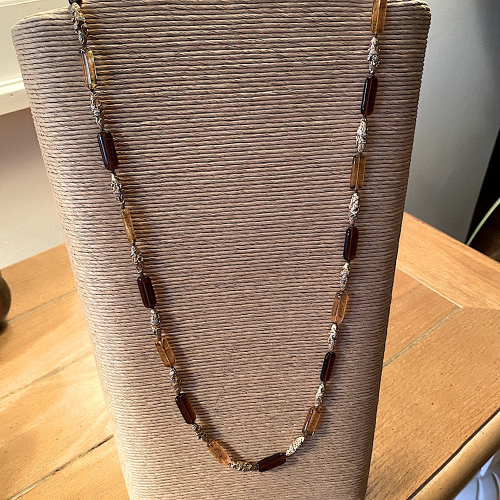 32” single strand necklace, brown glass and gold metal elongated beads.